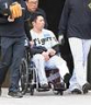 　車いすで球場を後にする石井（撮影・飯室逸平）