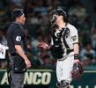 初回を終え、球審と話す伏見（撮影・西田忠信）